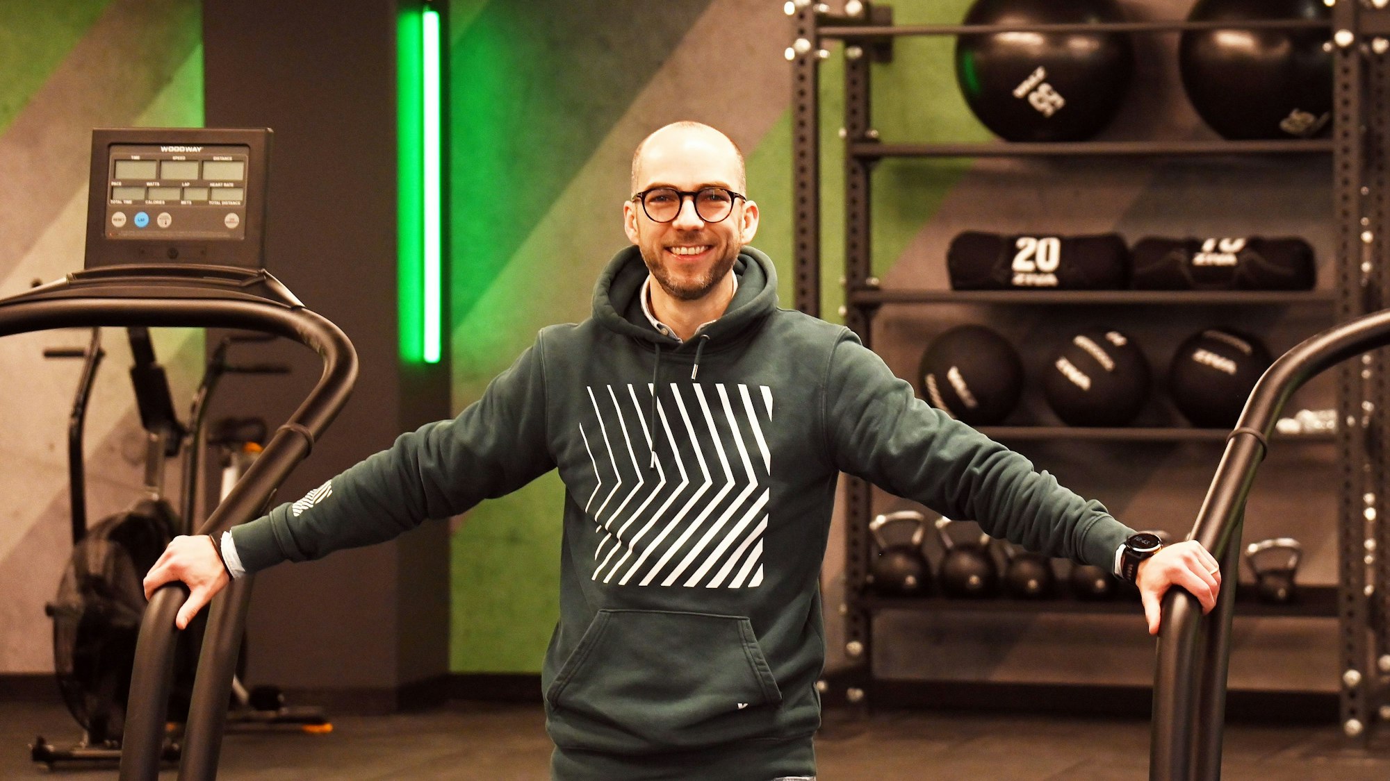 Fabian Menzel, Geschäftsführer der Kölner Fitnesskette Xtrafit, steht zwischen zwei Laufbändern im neuen Studio in der Schildergasse.