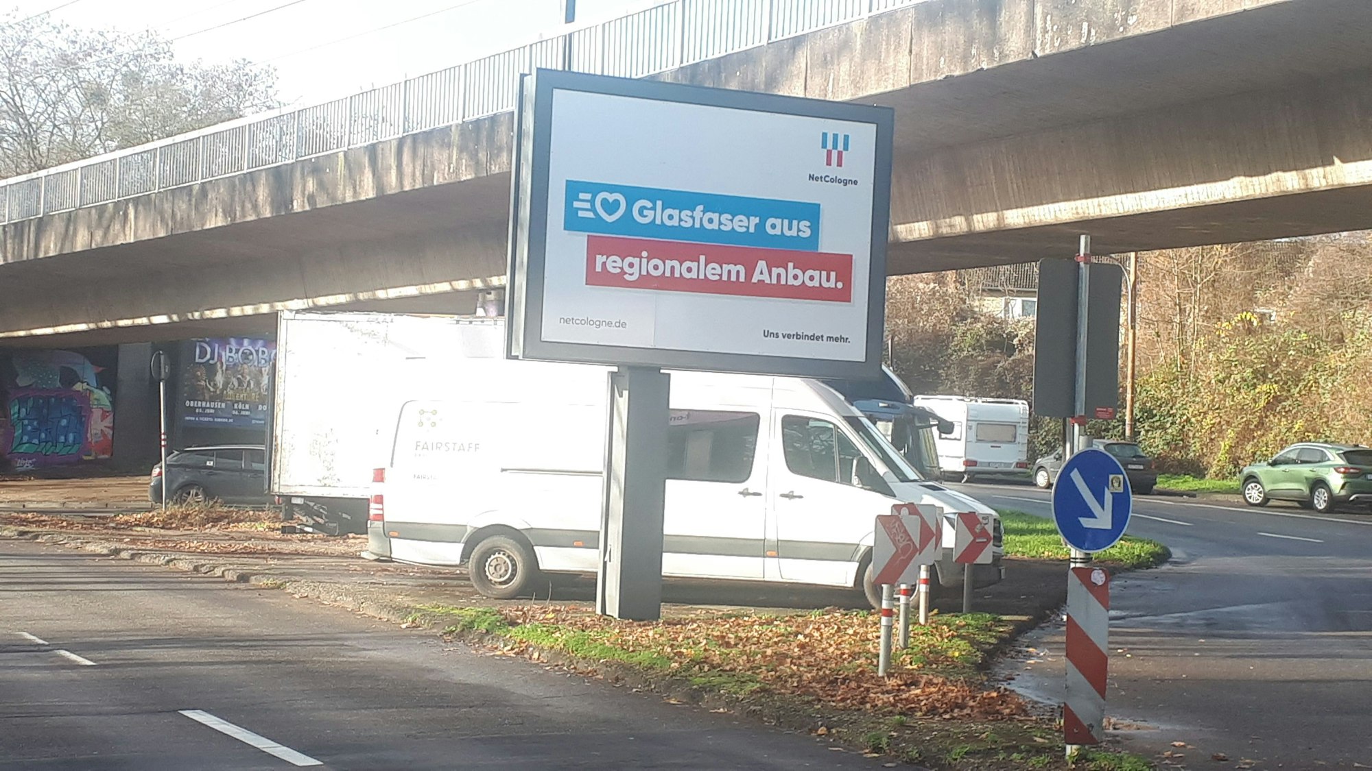 Autos parken zwischen den Pfeilern einer Hochbahntrasse.