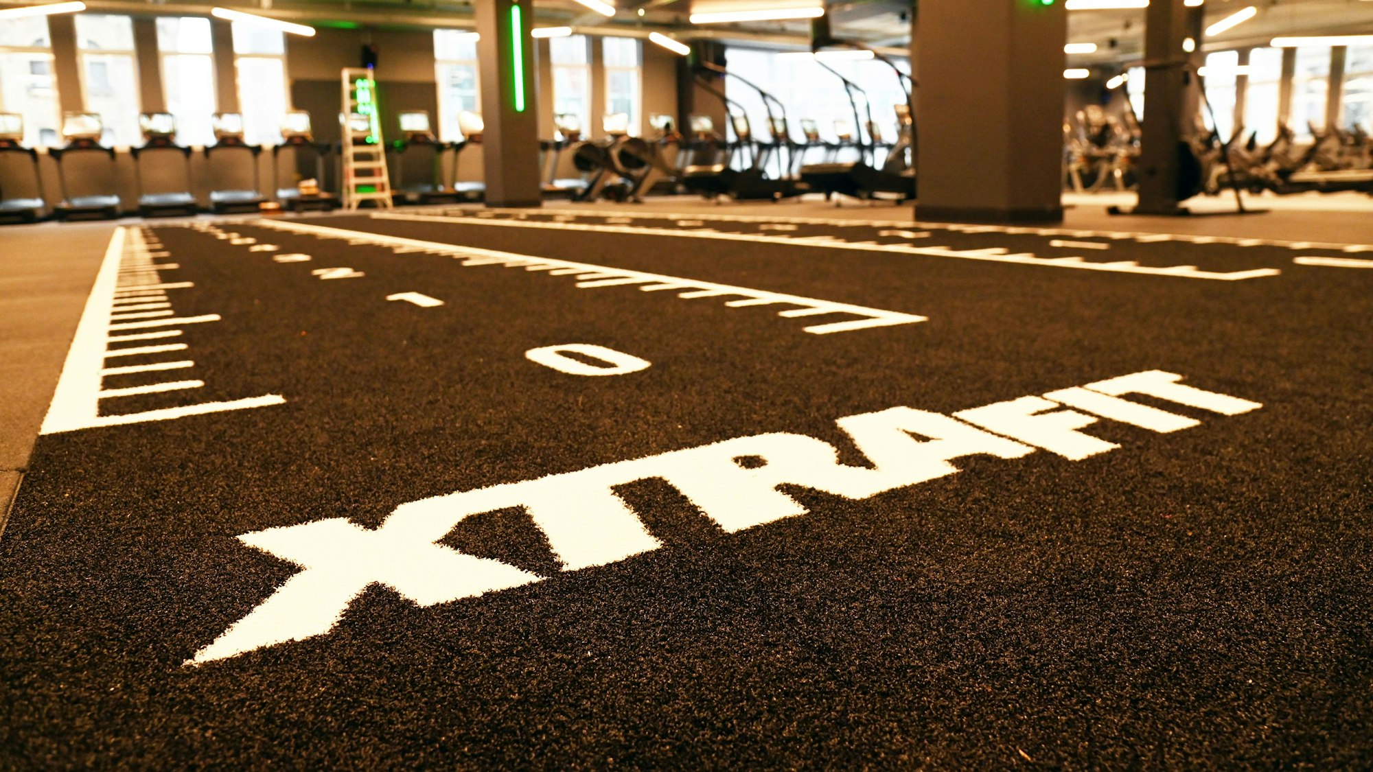 Schwarzer Kunstrasen mit weißen Markierungen, die die Strecke anzeigen.