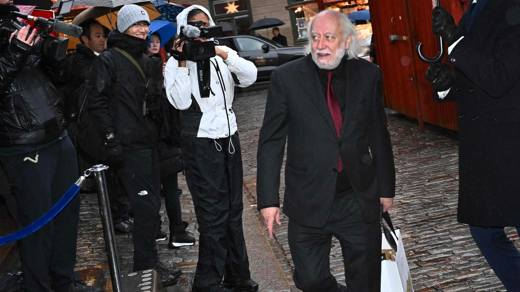 Hungarian Nobel Prize winning writer László Krasznahorkai (C) arrives along with other Nobel laureates to sign the Nobel Chairs at the Nobel Museum in Stockholm on December 6, 2025. (Photo by Claudio BRESCIANI / TT NEWS AGENCY / AFP) / Sweden OUT