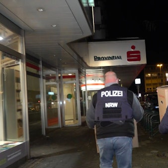 06.01.2026, Nordrhein-Westfalen, Gelsenkirchen: Einsatzkräfte der Polizei verlassen nach der Durchsuchung die Sparkassenfiliale mit Beweismaterial. Nach dem spektakulären Bank-Einbruch in Gelsenkirchen versuchen Ermittler weiter einen Überblick über den Schaden und das Vorgehen der Täter zu bekommen. Foto: Markus Gayk/dpa +++ dpa-Bildfunk +++