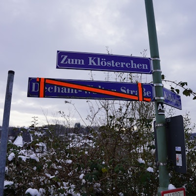 Der neue Straßenname „Zum Klösterchen“ hängt, noch ein Jahr aber soll in der Stadtmitte von Waldbröl auch das alte, inzwischen überklebte Schild sichtbar sein. Dieses erinnert an den Pfarrer und Dechant Emmerich Wolter. Dem Verstorbenen wird der sexuelle Missbrauch an Kindern vorgeworfen.