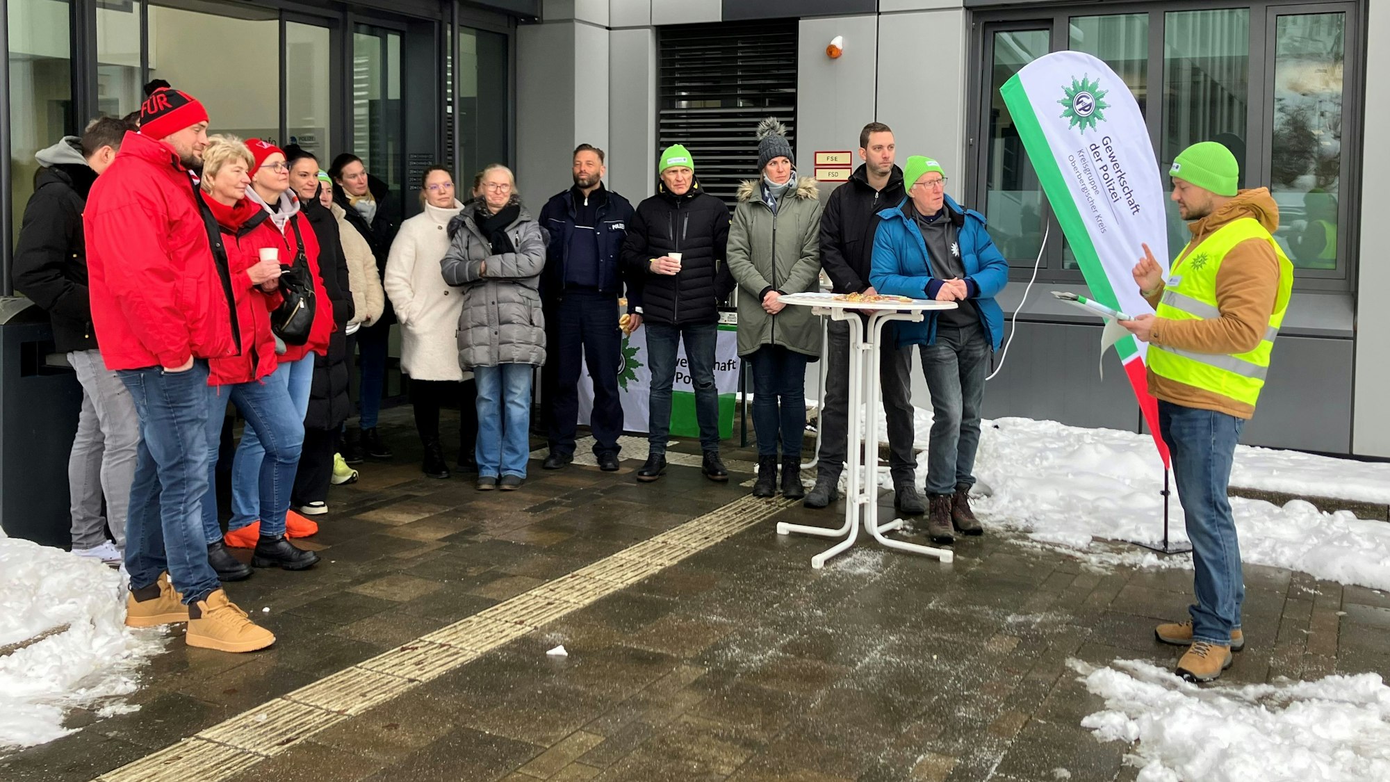 Eine Gruppe, darunter Gewerkschafter, steht vor dem Polizeigebäude in Gummersbach.
