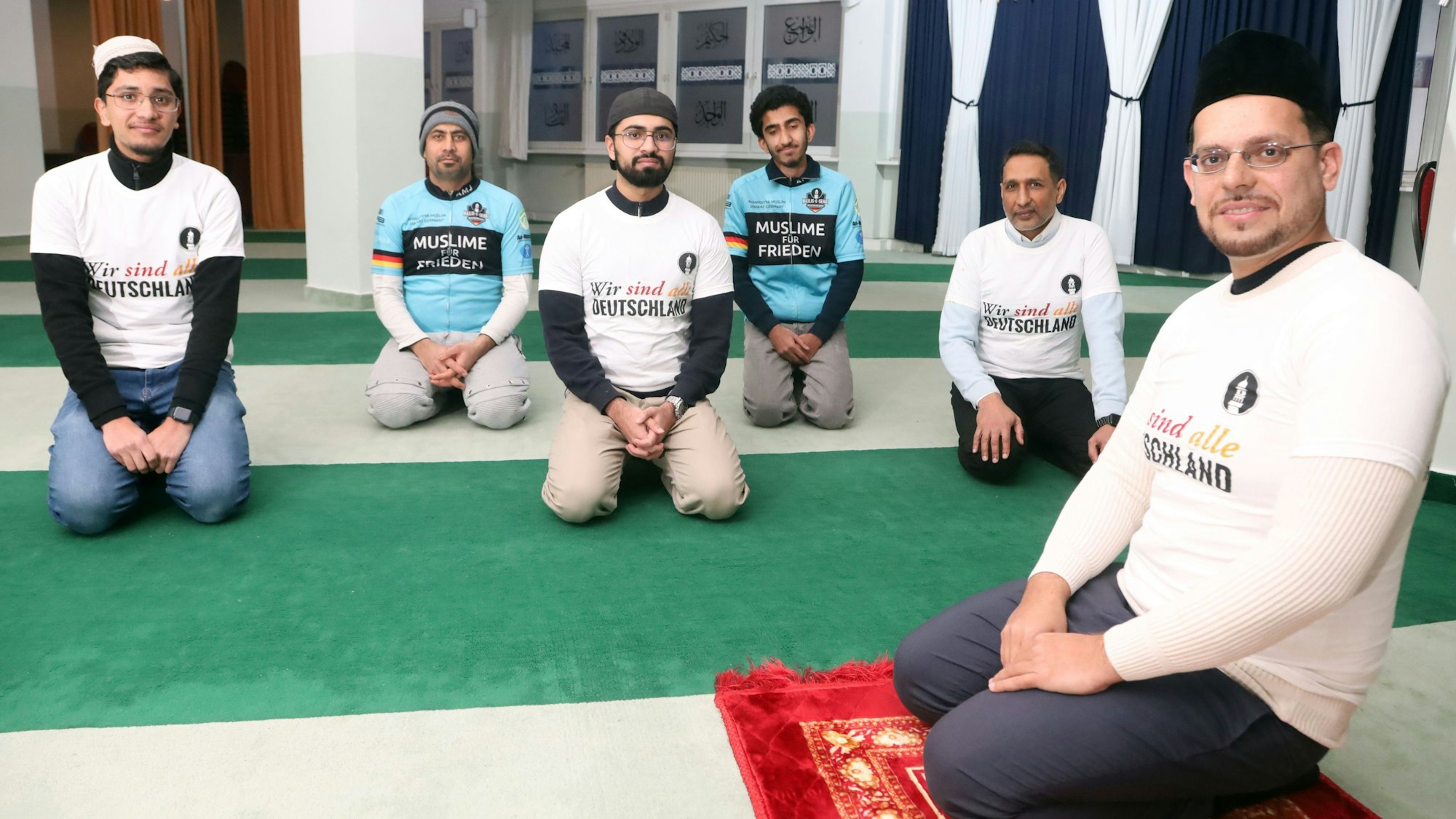 Das Bild zeigt Imam Shakeel Ahmed der Ahmadiyya-Gemeinde in der Bait-un-Nasr Moschee in Köln mit Männern und Jugendlichen in der Moschee. Foto: Arton Krasniqi