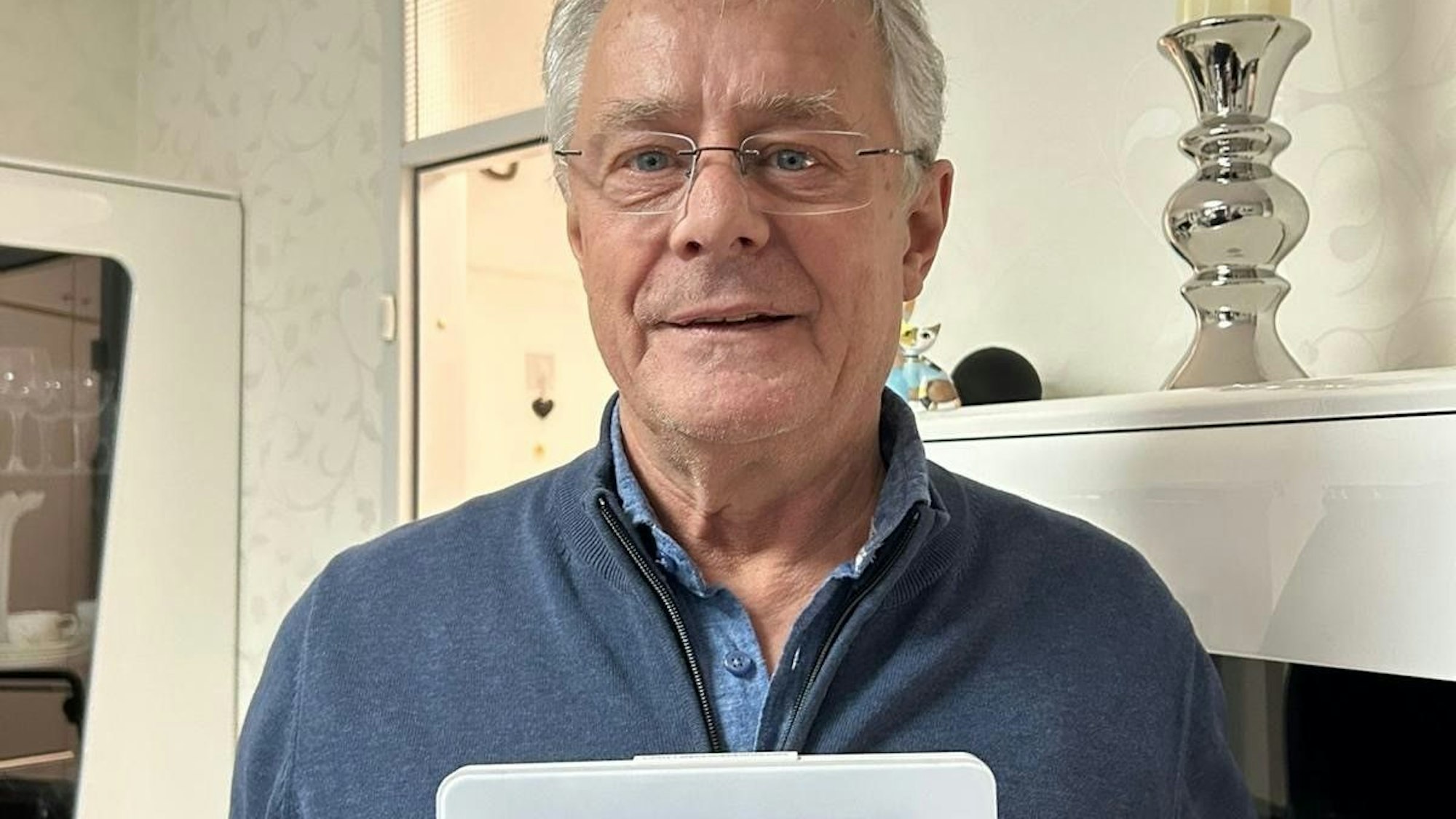 Hans Wirtz hält ein Thermometer, das 13 Grad anzeigt. So kalt ist es in seinem Schlafzimmer.