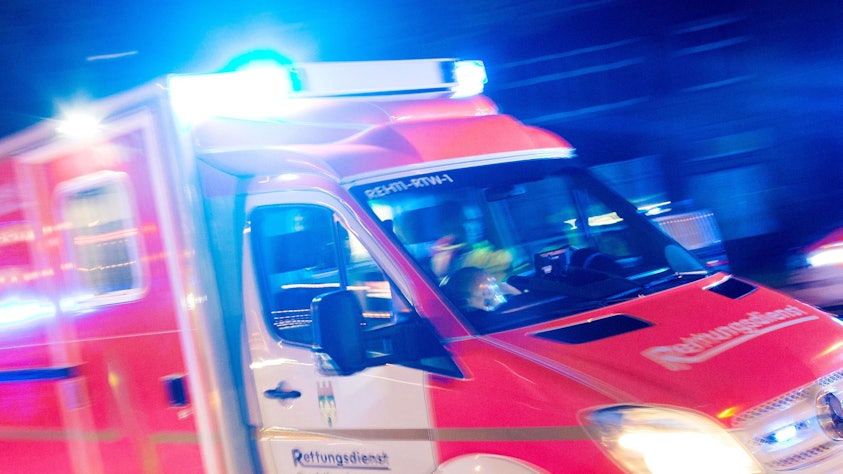Ein Rettungswagen der Feuerwehr fährt in Recklinghausen mit Blaulicht durch eine Straße.