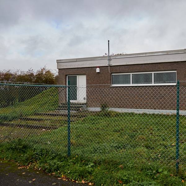 Aufnahme des Hochbehälters in Tondorf: Das unscheinbare Gebäude in Kastenform steht auf einem Hügel hinter einem Zaun.