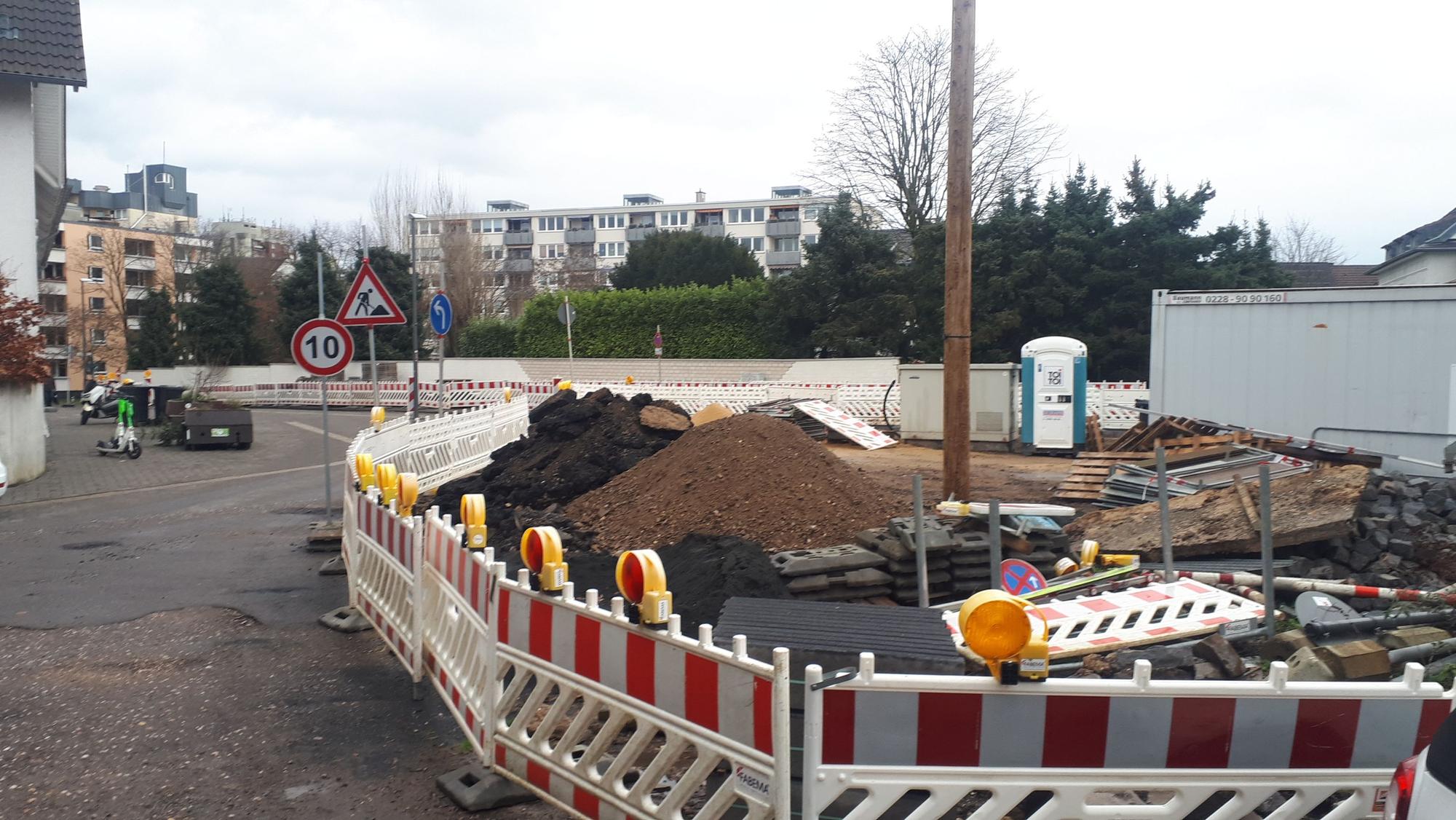Zu sehen ist ein kleiner Platz, der momentan als Baustellenfläche für eine Straßensanierung dient.