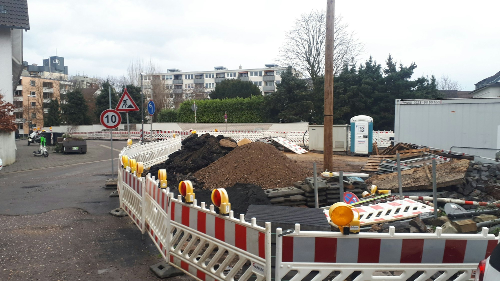 Zu sehen ist ein kleiner Platz, der momentan als Baustellenfläche für eine Straßensanierung dient.