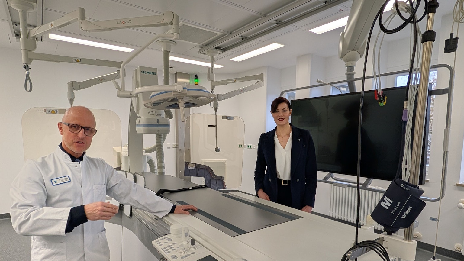 Das Foto zeigt den Chefarzt und die Geschäftsführerin im neuen Herzkatheterlabor.