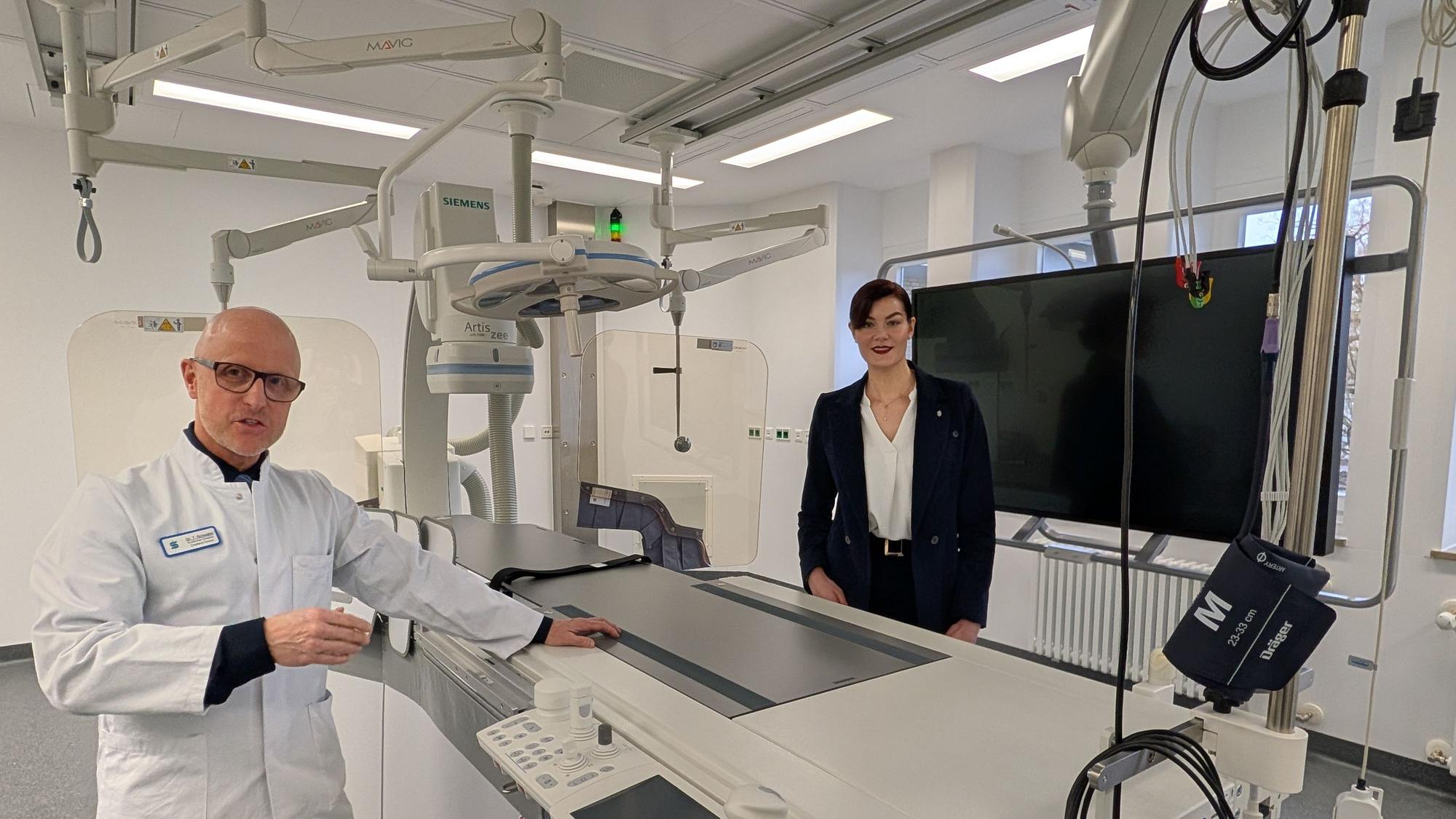 Das Foto zeigt den Chefarzt und die Geschäftsführerin im neuen Herzkatheterlabor.