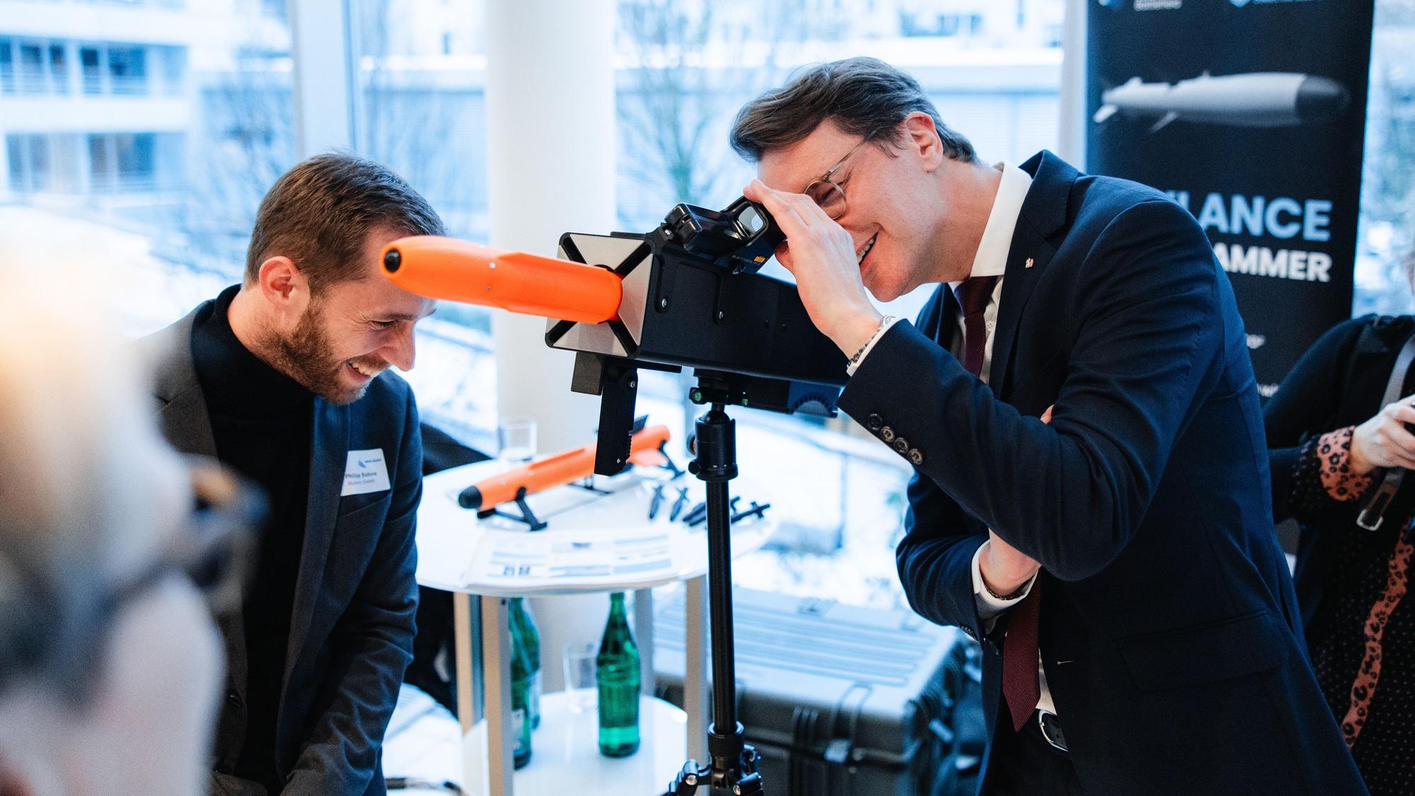 Hendrik Wüst begutachtet die Drohnenabwehrraketen des Hürther Startups Skylance.