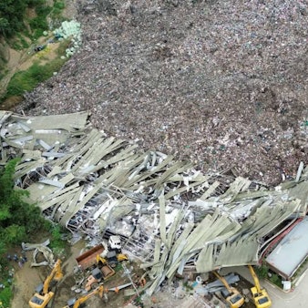 Mülldeponie mit eingestürztem Gebäude und Baugeräten