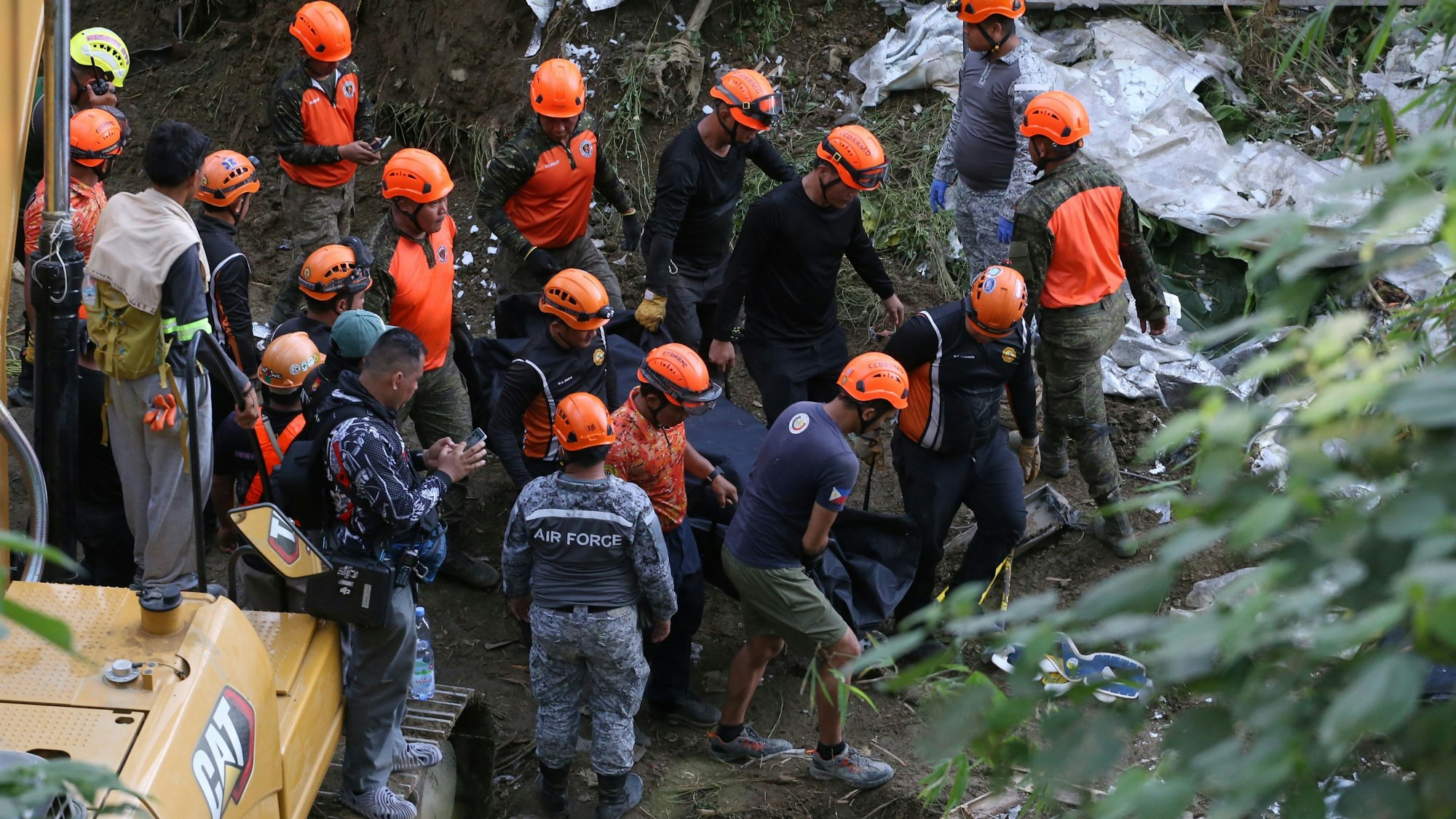 Rettungskräfte bergen eine Leiche aus einer eingestürzten Mülltrennungsanlage.
