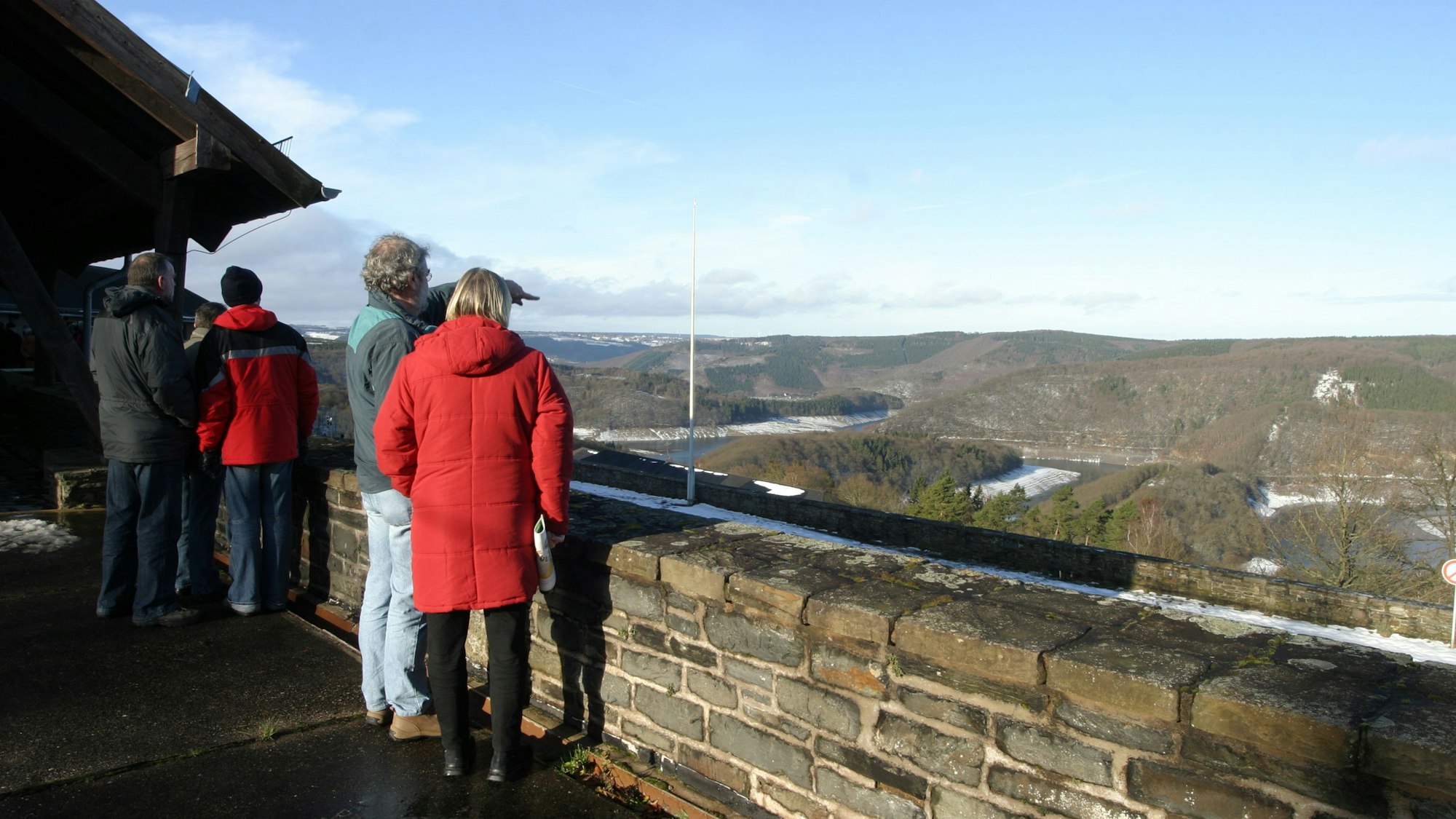 Menschen stehen an der Brüstung und schauen über den Urftsee.