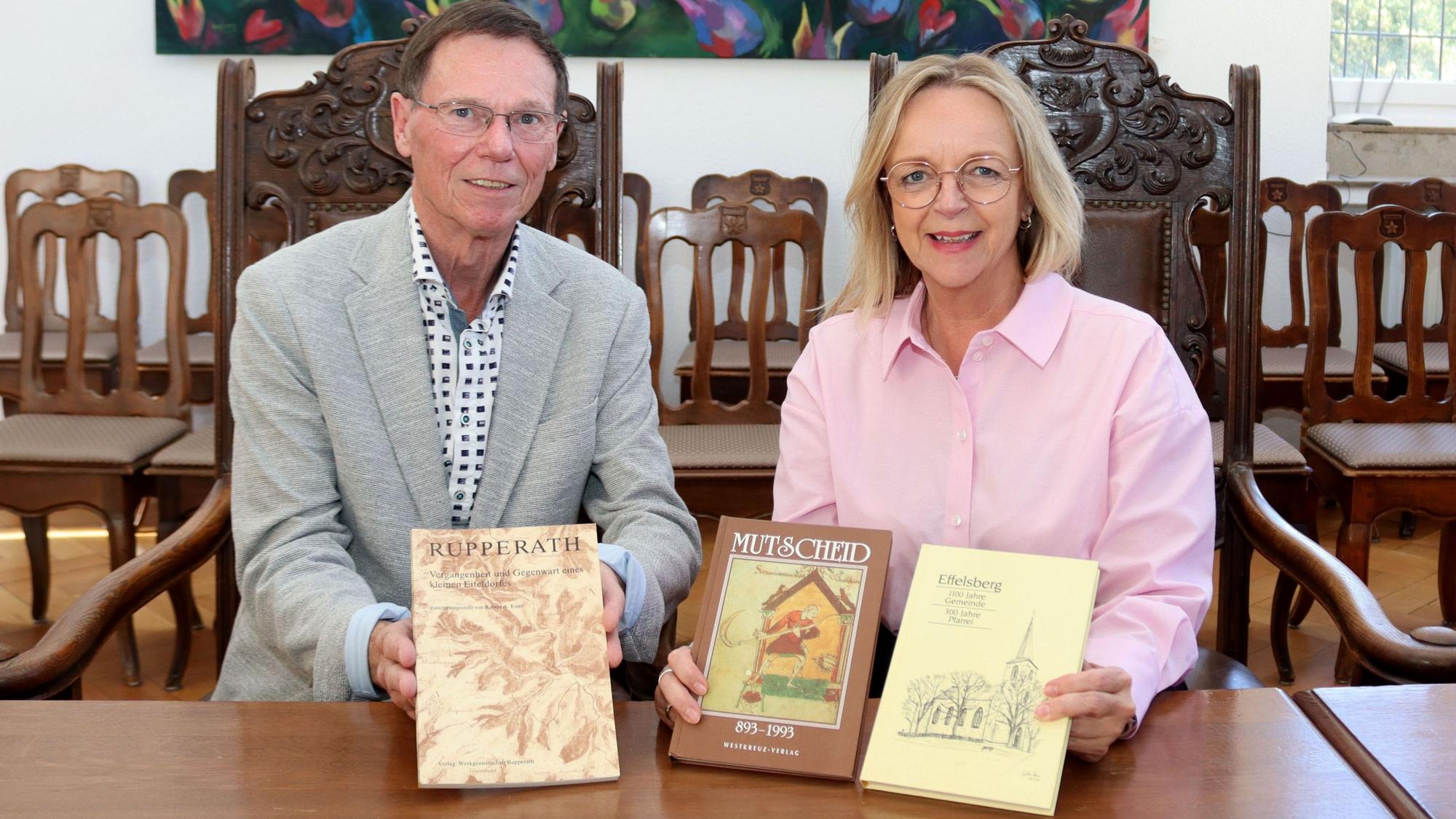 Paul Pfeiffer und Sabine Preiser-Marian halten drei Bücher in die Kamera.
