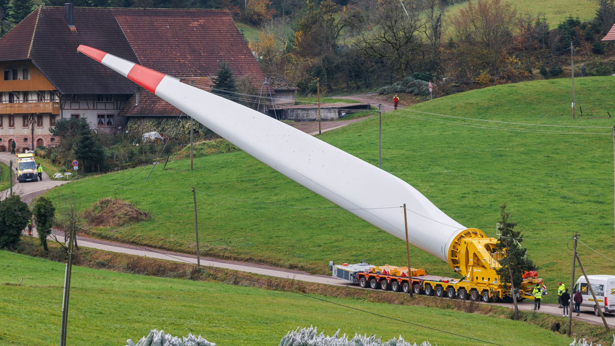 Ein Flügel eines Windrads ist auf einem sogenannten Selbstfahrer montiert und wird durch den Ort Prinzbach transportiert.
