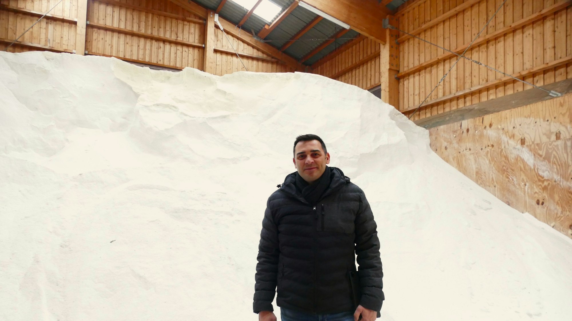 Adrian Förster, Leiter des Siegburger Baubetriebshof, steht vor dem Salzberg in der Halle.