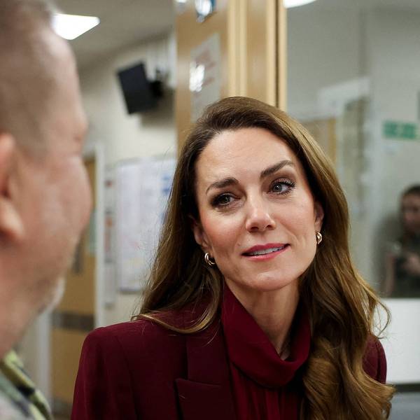 Prinzessin Kate schaut emotional und hört einem Mann zu.