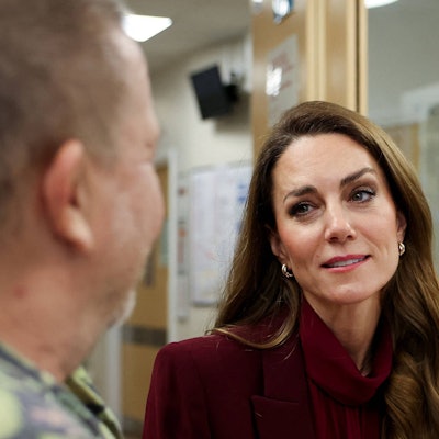 Prinzessin Kate schaut emotional und hört einem Mann zu.