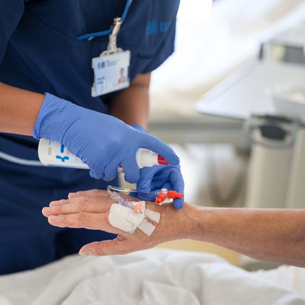 Eine Pflegekraft legt bei einem Patienten eine Infusion.