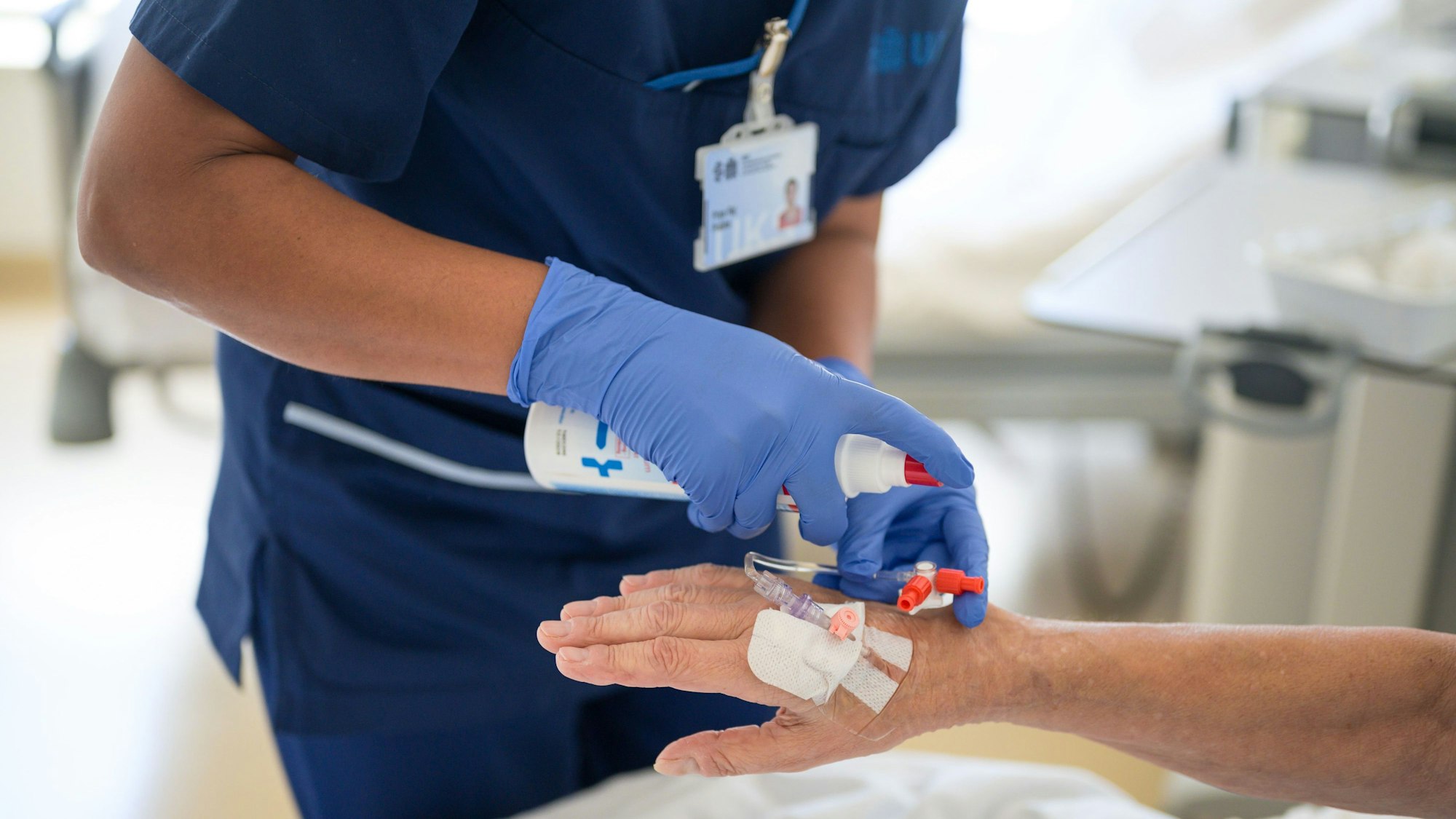 Eine Pflegekraft legt bei einem Patienten eine Infusion.