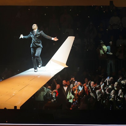 Apache 207 tanzt mit ausgebreiteten Armen auf dem Flügel eines Privatjets, lässt sich von seinen Fans in der Kölner Arena feiern.