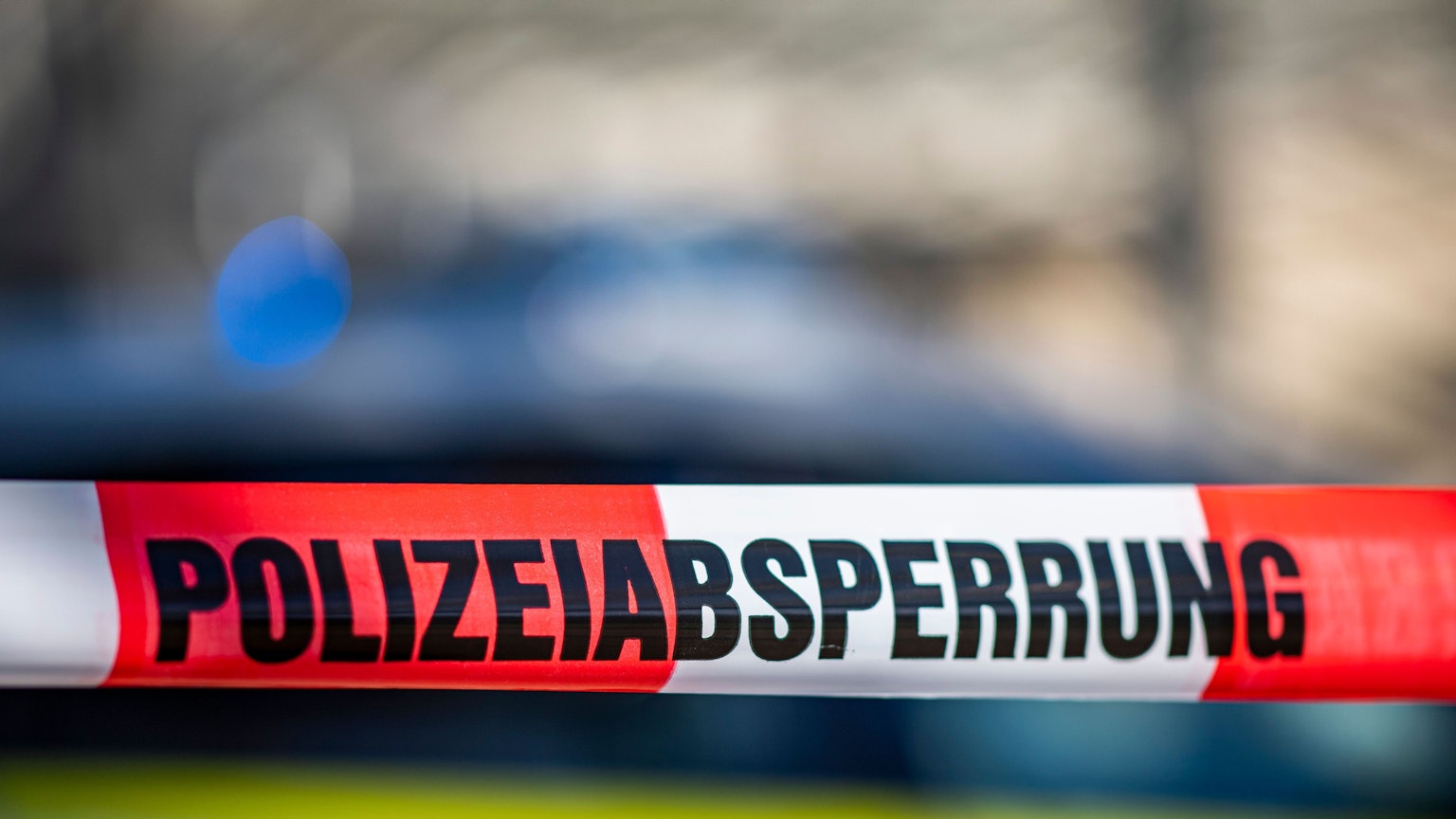 Ein Flatterband in rot-weiß mit der Aufschrift „Polizeiabsperrung“.