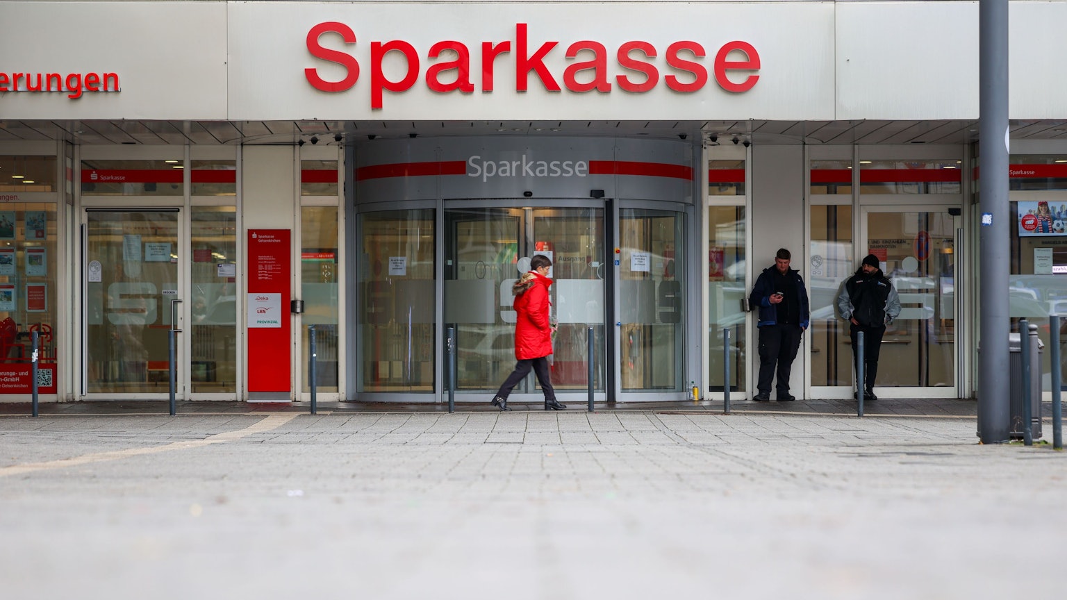 Security-Mitarbeiter stehen vor der nach dem spektakulären Einbruch geschlossenen Filiale der Sparkasse Gelsenkirchen.