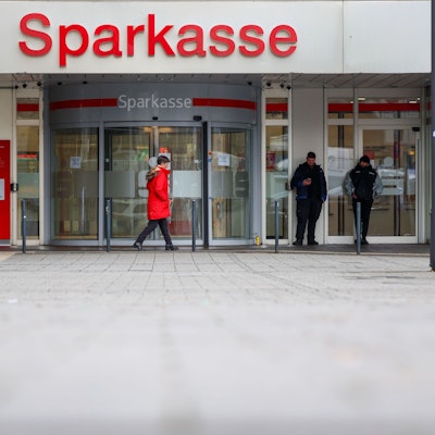 Security-Mitarbeiter stehen vor der nach dem spektakulären Einbruch geschlossenen Filiale der Sparkasse Gelsenkirchen.