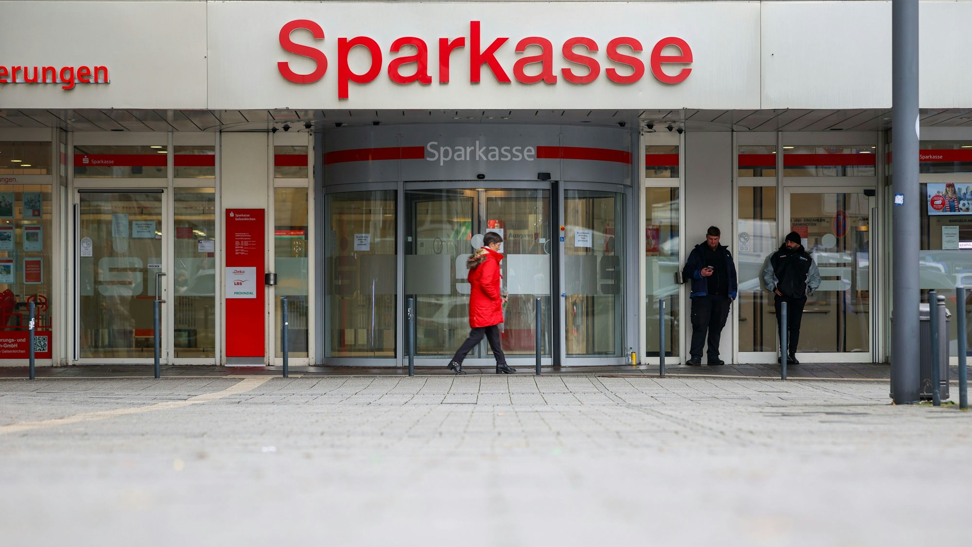 Security-Mitarbeiter stehen vor der nach dem spektakulären Einbruch geschlossenen Filiale der Sparkasse Gelsenkirchen.