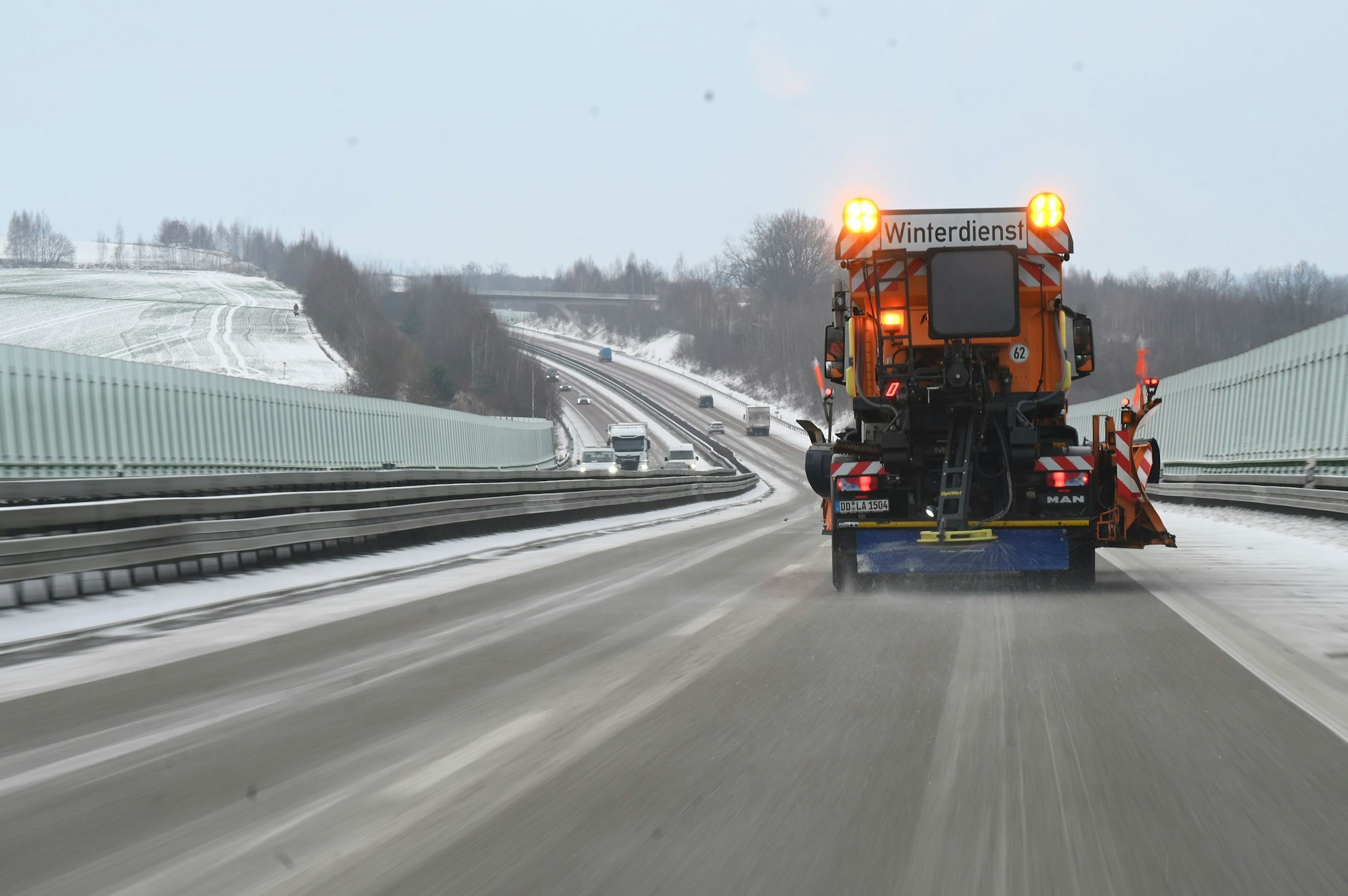 Ein Fahrzeug des Winterdienstes streut die Autobahn.