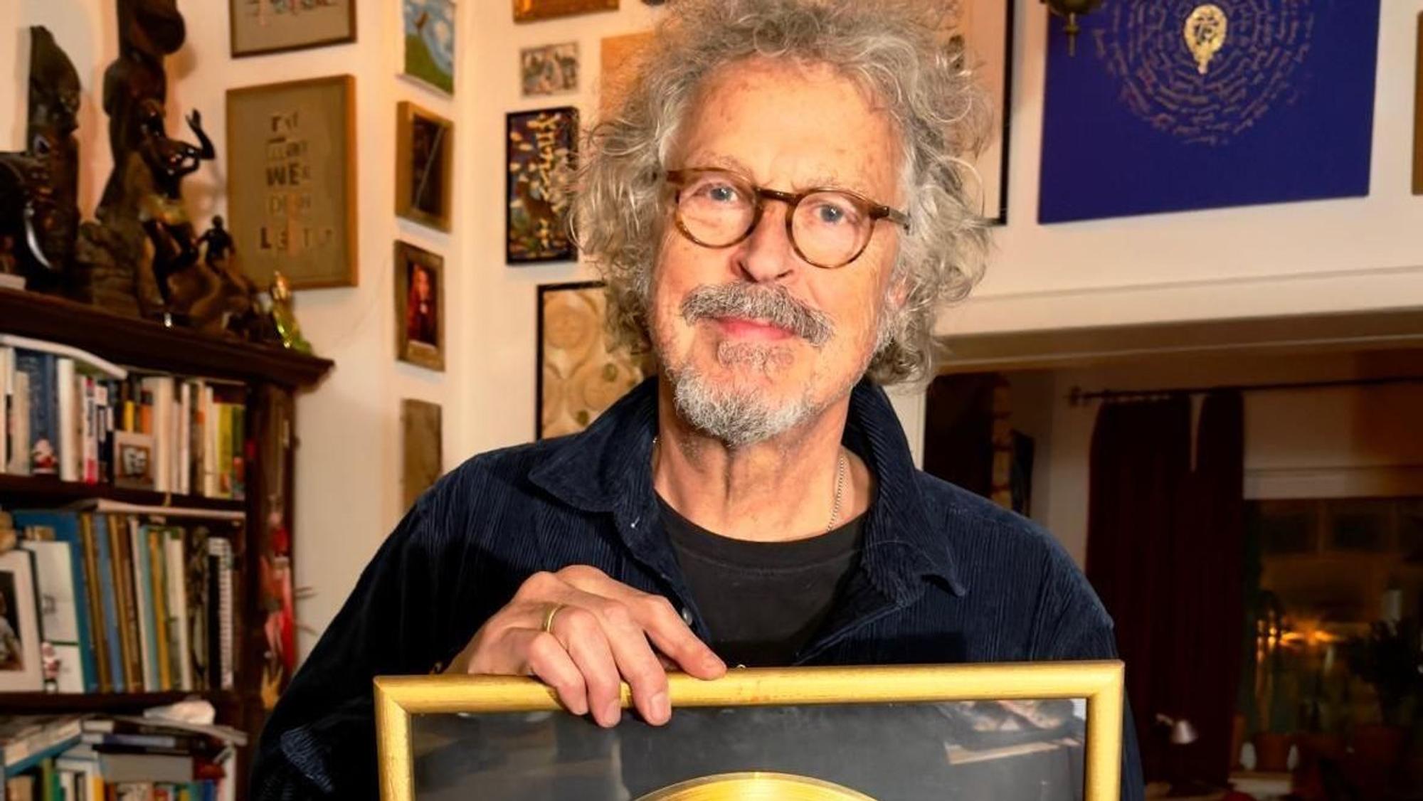 Wolfgang Niedecken zeigt seine Goldene Schallplatte.