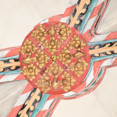 Der Schlussstein in einem gotischen Kreuzrippengewölbe. In der Mitte schaut ein Tütchen mit Gummibärchen hervor.