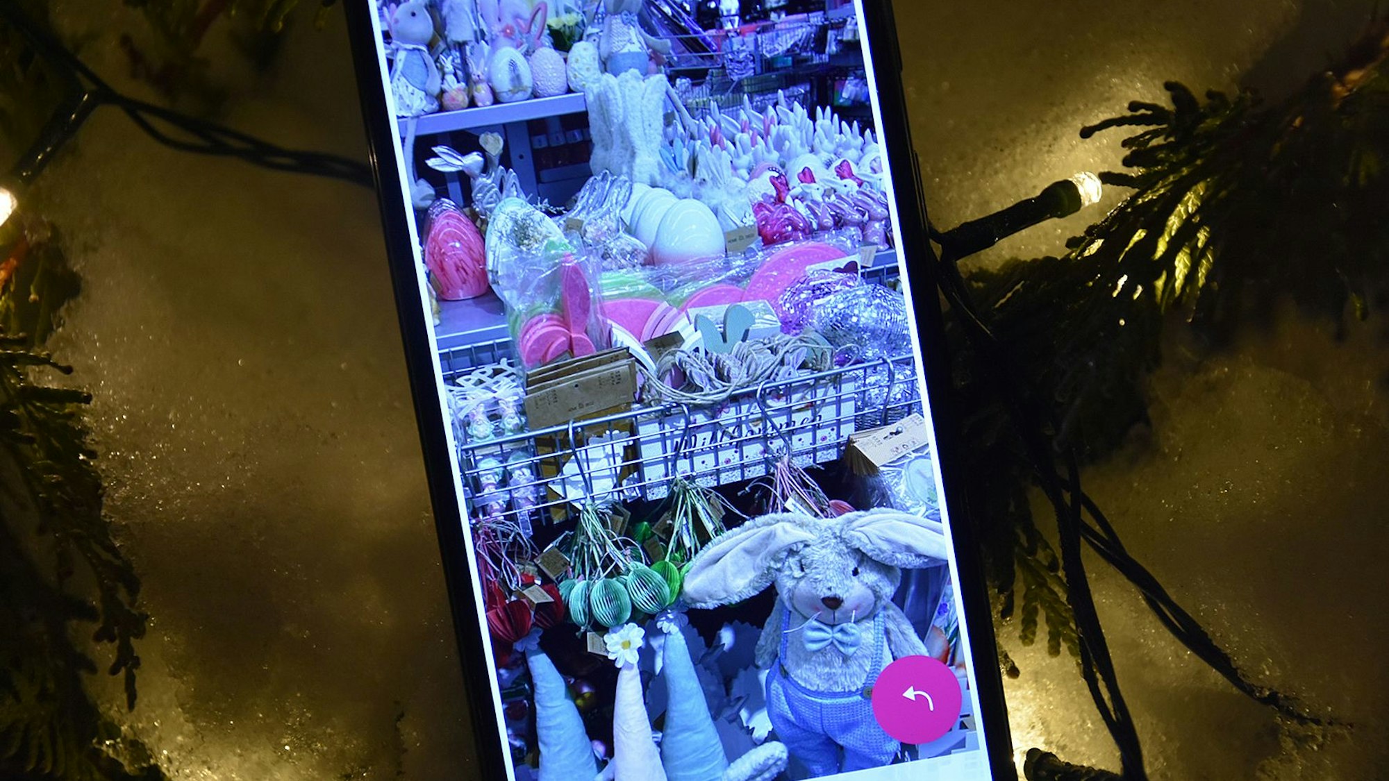 Eine Handy zeigt Osterdeko, dahinter eine Lichterkette.