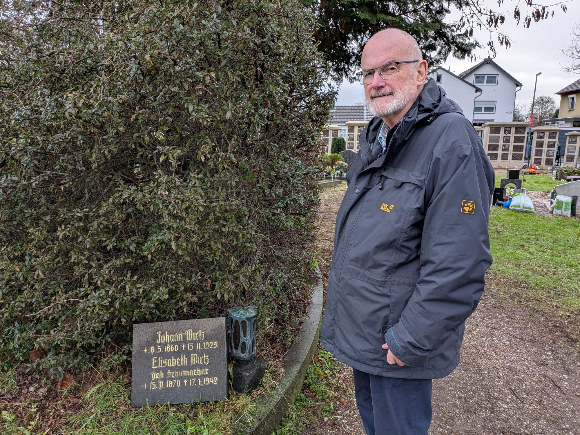 Gert Nicolini vor dem Grabstein von Johann Wirtz, den er vor dem Abräumen rettete