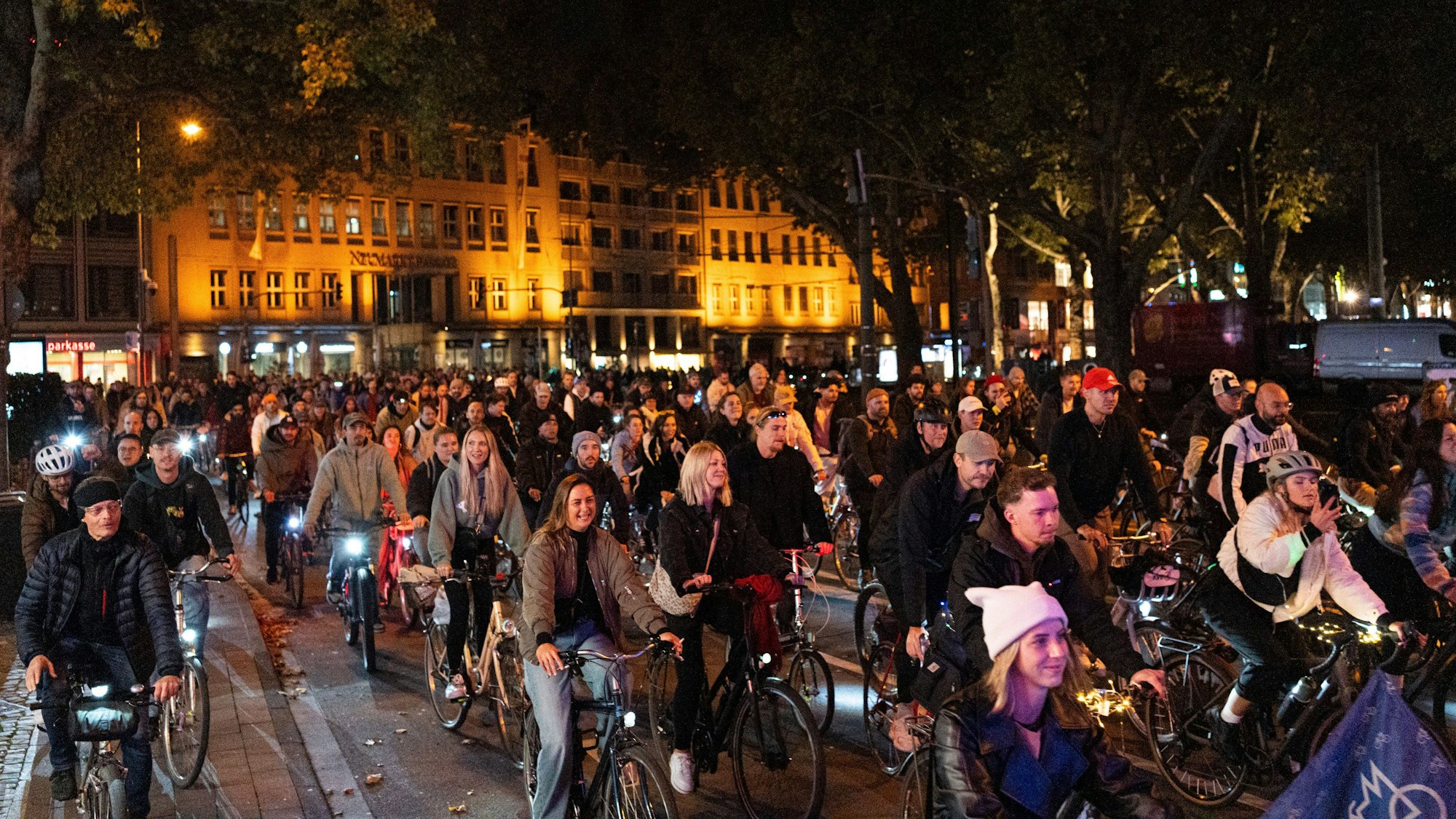 Menschenmasse auf Fahrrädern fährt am späten Abend durch Köln