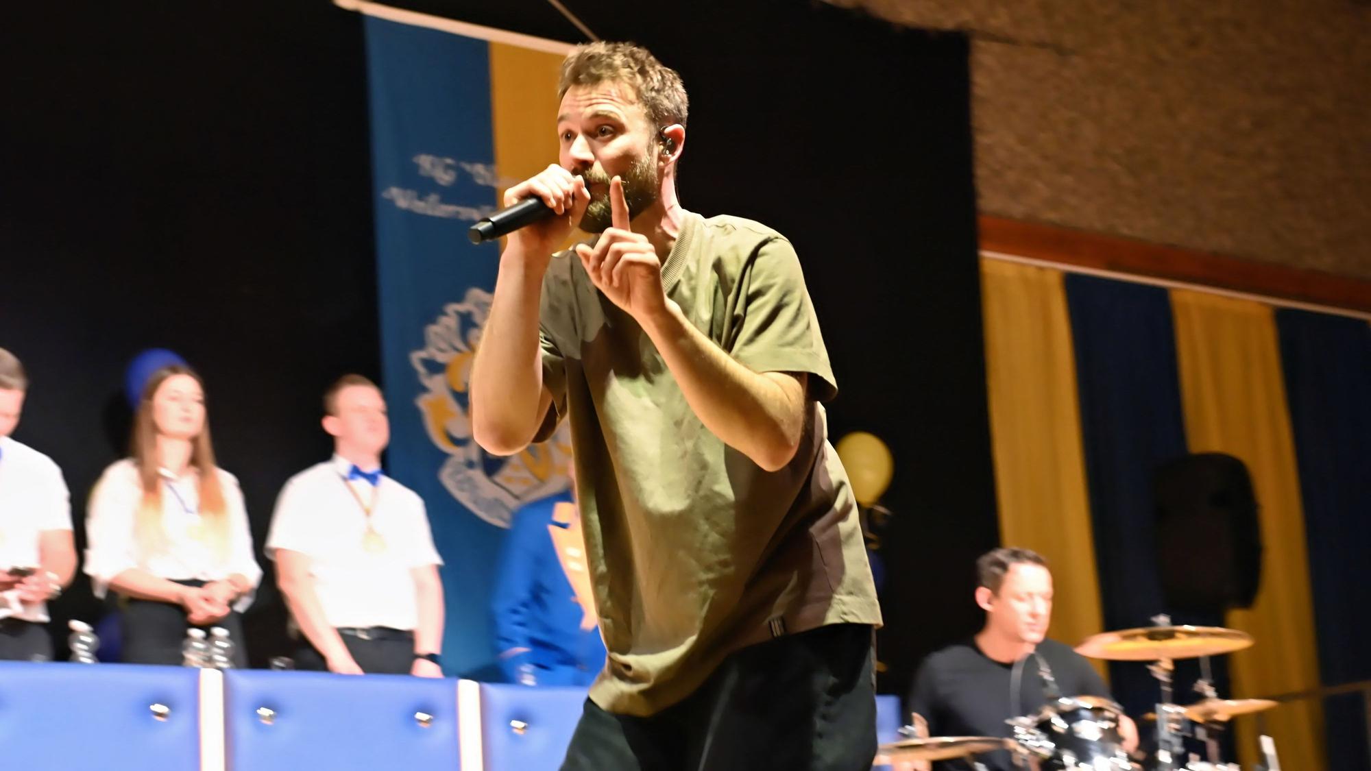 Der Sänger der Band „Stadtrand“ singt in ein Mikrofon.