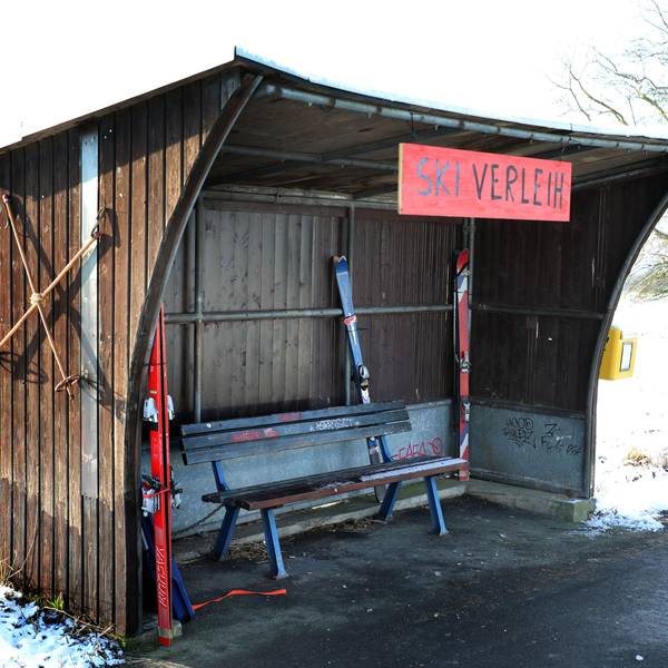 In einem Buswartehäuschen in Rösrath-Stöckchen stehen Ski und ein Rodelbob, ein Schild trägt die Aufschrift „Ski-Verleih“.