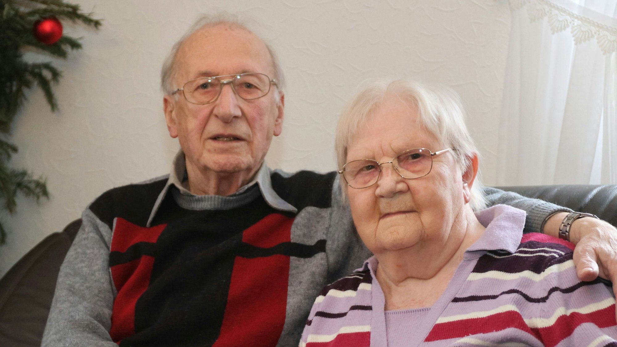 Helene und Christian Hüttling sitzen Arm in Arm nebeneinander.