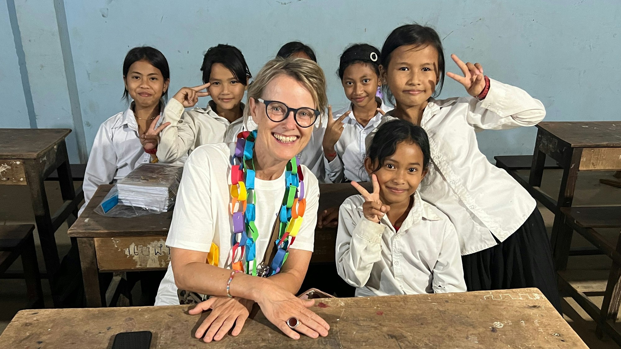 Marion Externbrink und Schülerinnen der Kandieng Sustainable School in Kambodscha lächeln in die Kamera.