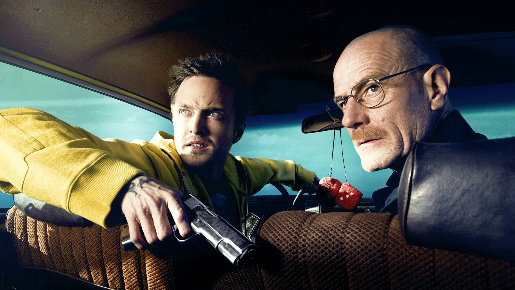 Aaron Paul und Bryan Cranston sitzen im Auto.