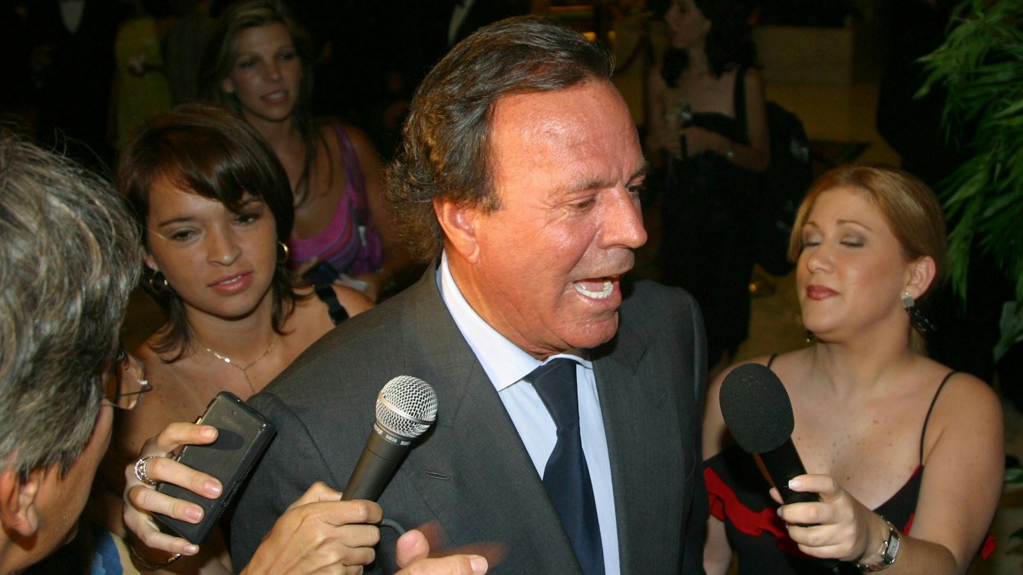 Julio Iglesias wird bei einer Gala von Pressevertretern umringt.