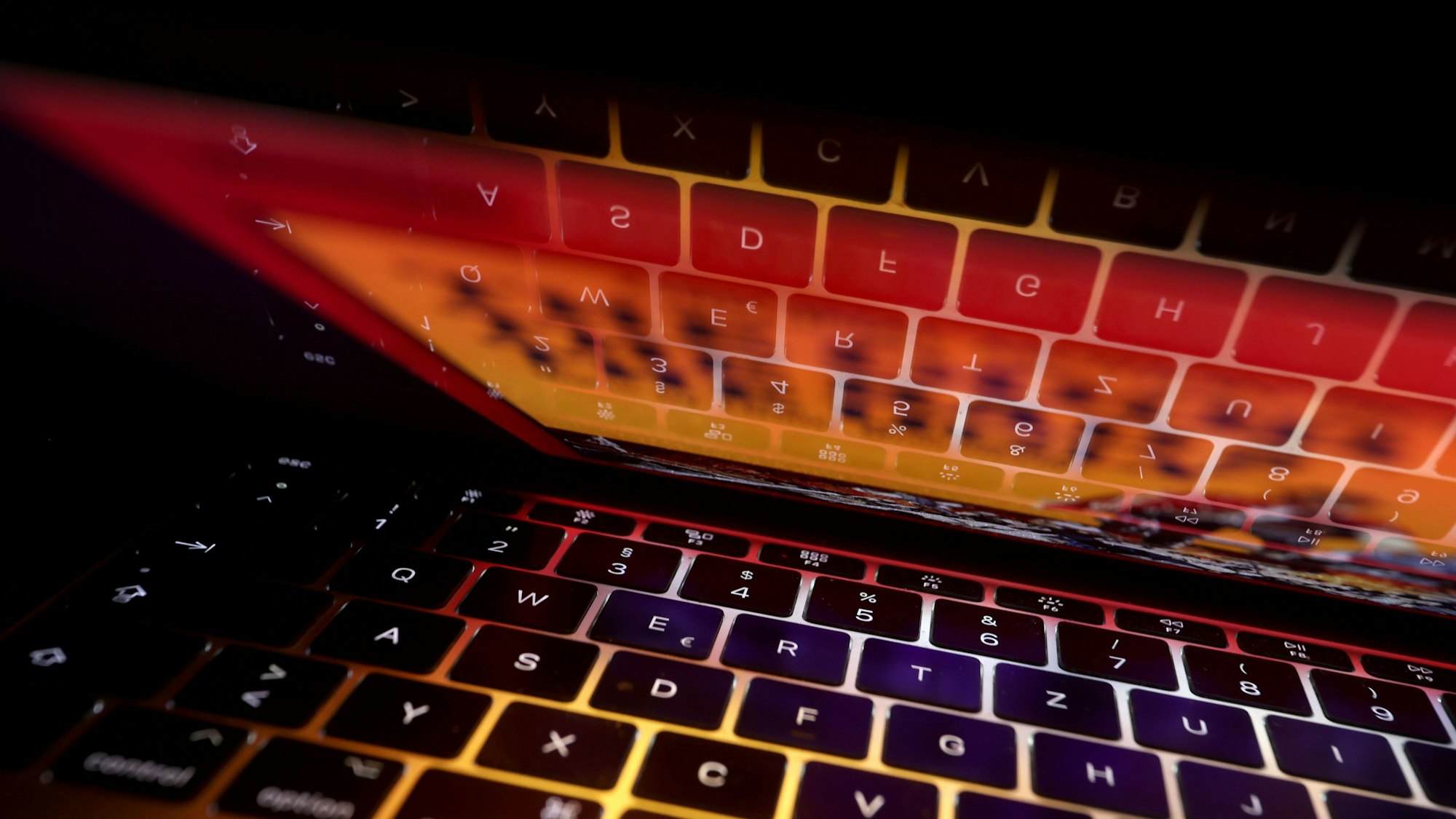 Die Tastatur eines Laptops spiegelt sich auf dem Bildschirm des Computers.