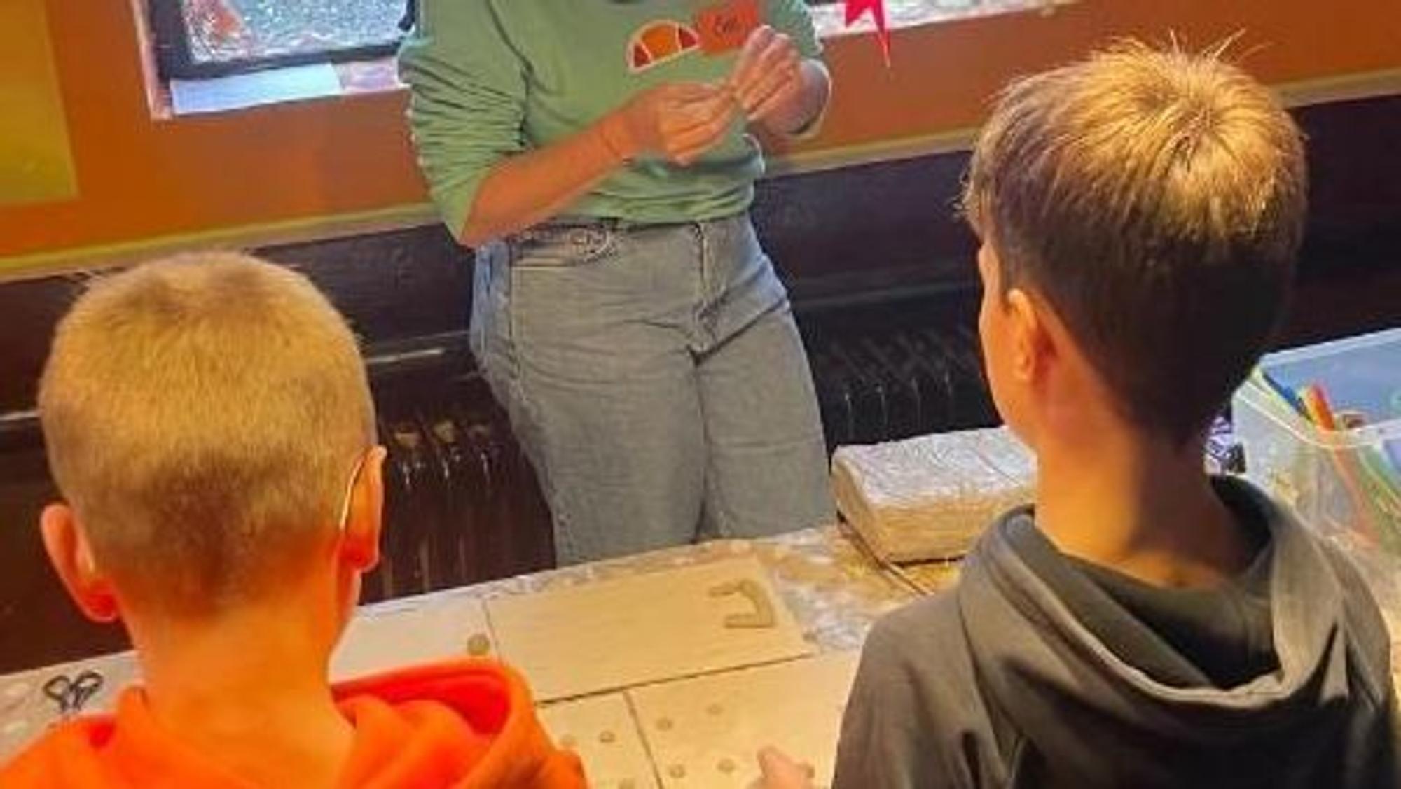Zwei Kinder basteln ihre persönliche Traum-Ojo aus Tonmaterial.