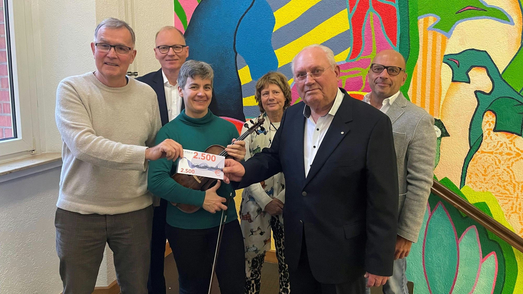 Manfred Wiethüchter übergibt die Spende an die Musikschule Leverkusen.