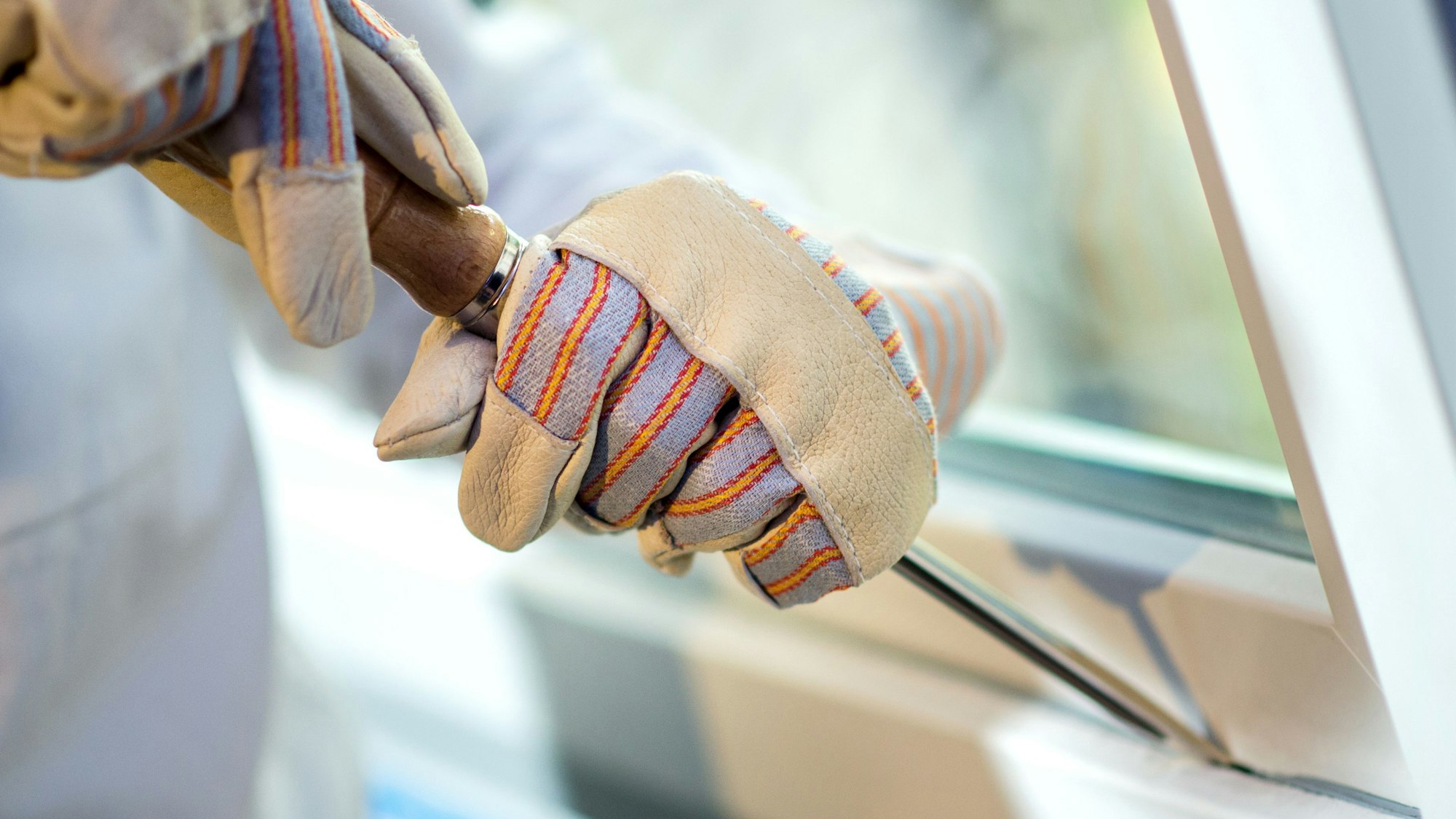 Ein Polizist demonstriert den Aufbruch eines Fensters.