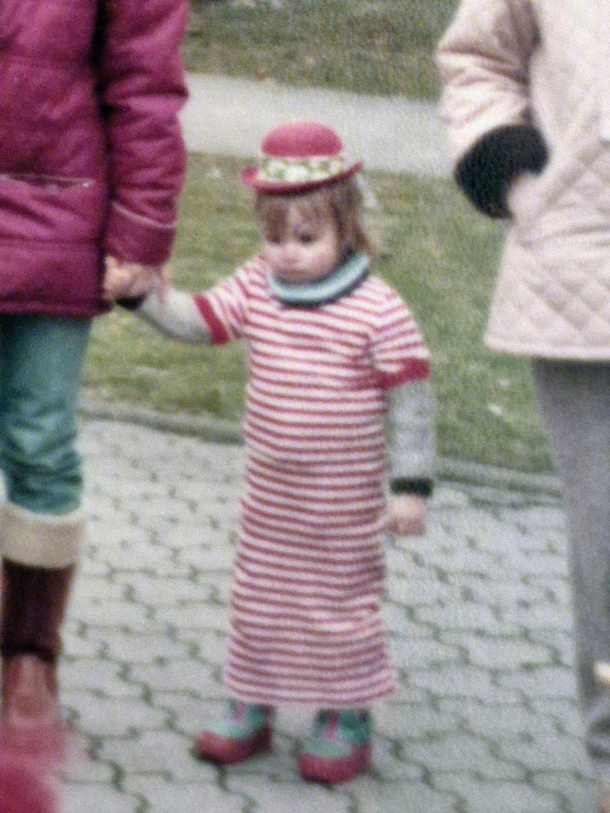 Thomas Schmitz steht im Ringelhemd und mit Hütchen im Karneval an der Hand einer Erwachsenen.