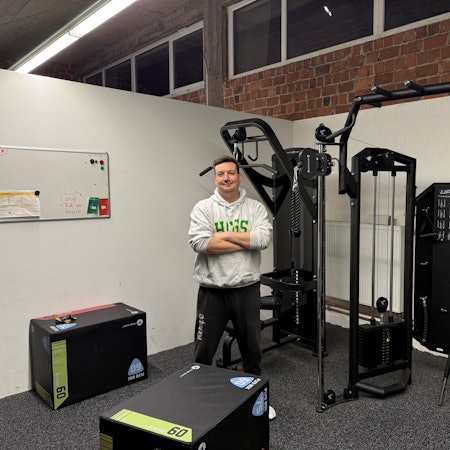 Patrick Kielgast steht mit verschränkten Armen im Kraftraum.