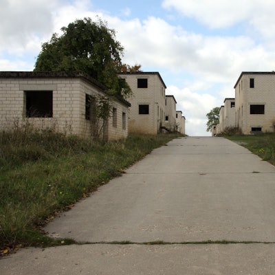 Rudimentäre Fassaden aus hellem Stein mit leeren Fenster- und Türöffnungen bilden eine Straßenzeile.